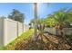 Well-maintained backyard with vinyl fence, palms, mulch and green grass at 13201 Wellington Hills Dr, Riverview, FL 33579