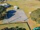 Aerial view shows basketball court with aging surface, tall lighting poles and trees on the perimeter at 13201 Wellington Hills Dr, Riverview, FL 33579