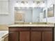 Bathroom with double vanity sinks, granite countertops, and a large mirror with vanity lighting at 13201 Wellington Hills Dr, Riverview, FL 33579