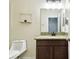 Bathroom vanity with granite countertop and decorative wall shelf at 13201 Wellington Hills Dr, Riverview, FL 33579