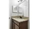 Bathroom sink with granite countertops, dark cabinets, and a framed mirror at 13201 Wellington Hills Dr, Riverview, FL 33579