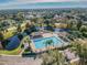 Aerial view of a sparkling community pool with lounge area, mature trees, and picturesque landscaping at 13201 Wellington Hills Dr, Riverview, FL 33579