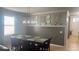 A well-lit dining area with a view into the hallway includes a dining table, decorative wall art, and large window at 13201 Wellington Hills Dr, Riverview, FL 33579