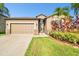 A one-story house shows well-manicured landscaping, a neutral siding and a two-car garage at 13201 Wellington Hills Dr, Riverview, FL 33579