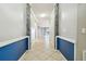 A long hallway features tile floors, wainscotting and stone accents at 13201 Wellington Hills Dr, Riverview, FL 33579