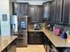 Kitchen showcases dark cabinets, granite counters, stainless steel appliances including a smart refrigerator at 13201 Wellington Hills Dr, Riverview, FL 33579
