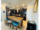 Modern kitchen with black cabinets, stainless steel appliances, and a stone-accented island with seating at 13201 Wellington Hills Dr, Riverview, FL 33579