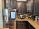 Kitchen featuring a stainless steel refrigerator, dark cabinets, and granite countertops at 13201 Wellington Hills Dr, Riverview, FL 33579