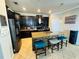 Modern kitchen with black cabinets, stainless steel appliances, and a stone-accented island with seating at 13201 Wellington Hills Dr, Riverview, FL 33579