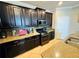 Kitchen featuring stainless steel appliances, granite countertops, dark cabinets, and a view of the eat-in kitchen area at 13201 Wellington Hills Dr, Riverview, FL 33579