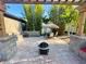 Backyard brick patio with fire pit, dining under a tiki umbrella, complemented by lush bamboo and serene landscape at 13201 Wellington Hills Dr, Riverview, FL 33579