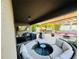 Inviting outdoor patio with a covered lounge area, TV, grill station, and a charming pergola-covered dining space at 13201 Wellington Hills Dr, Riverview, FL 33579