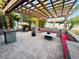 Outdoor brick patio featuring a pergola, seating, and a tropical ambiance with surrounding bamboo and a tiki umbrella at 13201 Wellington Hills Dr, Riverview, FL 33579