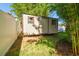 Backyard shed for extra storage with sliding door, surrounded by bamboo and white fence at 13201 Wellington Hills Dr, Riverview, FL 33579