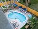 Aerial view of a backyard oasis with a pool, hammocks, seating areas, and games at 1394 Stonehenge Way, Palm Harbor, FL 34683