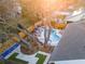 Aerial view of a backyard with a pool, lounge area, outdoor bowling alley, and putting green at 1394 Stonehenge Way, Palm Harbor, FL 34683