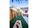 Backyard featuring artificial turf, outdoor lighting, and fun games to offer year-round enjoyment at 1394 Stonehenge Way, Palm Harbor, FL 34683