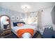 Comfortable bedroom with a serene atmosphere featuring a bed, a blue chair, and a lovely window view at 1394 Stonehenge Way, Palm Harbor, FL 34683