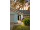 Charming home exterior featuring a blue accent wall, well-lit entrance, and lush landscaping at 1394 Stonehenge Way, Palm Harbor, FL 34683