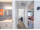 Open hallway featuring a bathroom with a single sink vanity and entry to the living room at 1394 Stonehenge Way, Palm Harbor, FL 34683