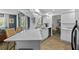 Bright kitchen featuring a white quartz countertop and cabinetry, stainless steel appliances, and wood flooring at 1394 Stonehenge Way, Palm Harbor, FL 34683