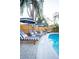 Close-up of the pool and lounge chairs, with umbrellas providing shade and comfort at 1394 Stonehenge Way, Palm Harbor, FL 34683