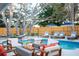 Luxurious backyard featuring a sparkling pool, comfortable lounge chairs, and a cozy fire pit area at 1394 Stonehenge Way, Palm Harbor, FL 34683