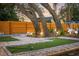 Backyard putting green and outdoor bowling alley surrounded by lush landscaping and mature trees at 1394 Stonehenge Way, Palm Harbor, FL 34683