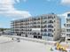 Multi-story beachfront condo building featuring balconies, beach access, and blue accents at 14300 Gulf Blvd # 401, Madeira Beach, FL 33708
