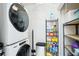 Convenient laundry room with stacked washer and dryer and storage shelves at 14300 Gulf Blvd # 401, Madeira Beach, FL 33708