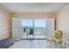 Living room featuring tile flooring, shutters, and ocean views through sliding glass doors at 14300 Gulf Blvd # 401, Madeira Beach, FL 33708