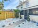 Well-maintained backyard with a concrete walkway, decorative rock landscaping, a fire pit, and a privacy fence at 14611 Pine Glen Cir, Lutz, FL 33559