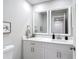 Modern bathroom features white cabinetry, dual mirrors, and a quartz countertop at 14611 Pine Glen Cir, Lutz, FL 33559