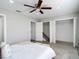 Bright bedroom featuring wood-look floors, a ceiling fan, access to closets, and natural light at 14611 Pine Glen Cir, Lutz, FL 33559