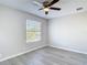 Bright bedroom with wood-look floors, a ceiling fan, and a large window at 14611 Pine Glen Cir, Lutz, FL 33559