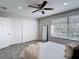 Bright bedroom features a ceiling fan, closet, and sunny windows with white horizontal blinds at 14611 Pine Glen Cir, Lutz, FL 33559