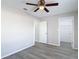 Bright bedroom featuring wood-look floors, a ceiling fan, and access to a walk-in closet at 14611 Pine Glen Cir, Lutz, FL 33559
