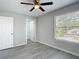 Bright bedroom featuring wood-look floors, a ceiling fan, and an open closet at 14611 Pine Glen Cir, Lutz, FL 33559