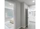 Hallway featuring an open doorway with an ensuite bathroom and a bedroom with neutral decor at 14611 Pine Glen Cir, Lutz, FL 33559
