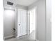 Hallway with an open door, light grey walls, and light floors at 14611 Pine Glen Cir, Lutz, FL 33559