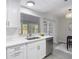 Bright kitchen showcases stainless steel dishwasher and white cabinets, adjacent to a dining area at 14611 Pine Glen Cir, Lutz, FL 33559