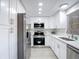 Modern kitchen features stainless steel appliances, white cabinets, and sleek countertops at 14611 Pine Glen Cir, Lutz, FL 33559