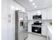 Bright modern kitchen features stainless steel appliances, sleek countertops, and white cabinets at 14611 Pine Glen Cir, Lutz, FL 33559