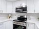Modern kitchen features stainless steel appliances, quartz countertops and white cabinetry at 14611 Pine Glen Cir, Lutz, FL 33559