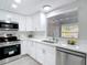 This bright kitchen features stainless steel appliances, white cabinets, and a window view at 14611 Pine Glen Cir, Lutz, FL 33559