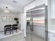 Bright kitchen adjacent to dining room showcases stainless steel refrigerator and white cabinetry at 14611 Pine Glen Cir, Lutz, FL 33559