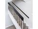 Bright staircase features white risers and stringers paired with modern wood treads and black handrails at 14611 Pine Glen Cir, Lutz, FL 33559