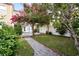 Backyard featuring lush greenery, vibrant flowers, and a charming wooden swing, creating a serene and inviting outdoor space at 14648 Bournemouth Rd, Tampa, FL 33626