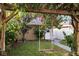Backyard showcasing a wooden swing beneath a tree, complemented by colorful flowers and lush greenery, offering tranquil scenery at 14648 Bournemouth Rd, Tampa, FL 33626