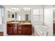 Spacious bathroom with double sinks, a soaking tub, and a large mirror at 14648 Bournemouth Rd, Tampa, FL 33626